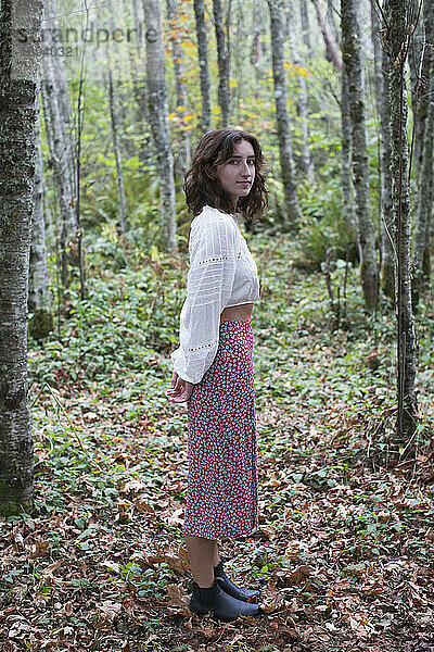 Porträt eines siebzehnjährigen Mädchens  das im üppigen Wald im Herbst steht  Discovery Park  Seattle  Washington