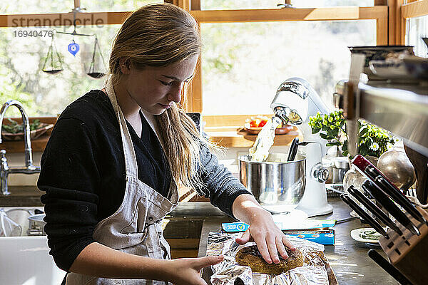 Teenager-Mädchen in der Küche backen einen Kuchen.