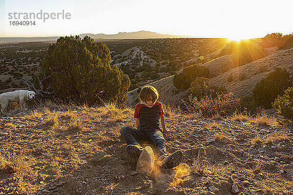 Junger Junge im Galisteo Basin bei Sonnenuntergang mit seinem English Cream Golden Retreiver