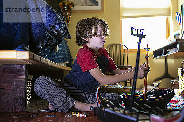 7 Jahre alter Junge spielt mit seinem Spielzeug in seinem Zimmer