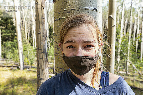 Teenager-Mädchen mit COVID-19-Maske im Espenwald
