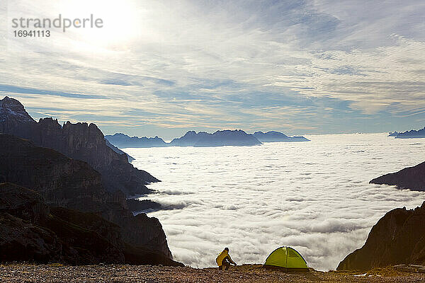 Mann und Zelt über den Wolken  Trentino-Südtirol im Bezirk Bozen  Hochpustertal  Sextner Dolomiten  Italien