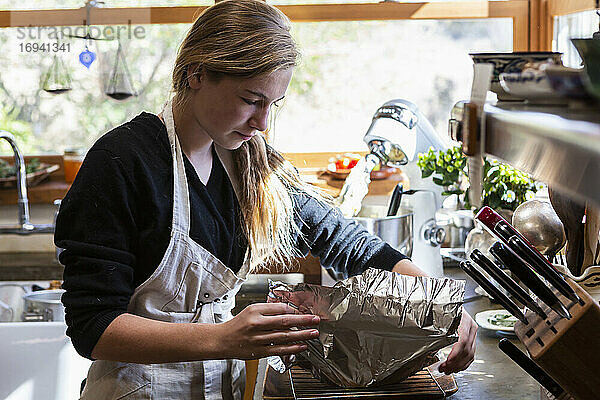 Teenager-Mädchen in der Küche backen einen Kuchen.