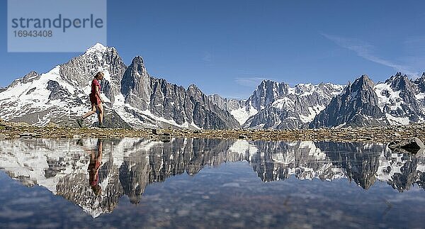 Junge Frau wandert vor Bergpanorama  Spiegelung im Lac Blanc  Berggipfel  Grandes Jorasses und Mont-Blanc-Massiv  Chamonix-Mont-Blanc  Haute-Savoie  Frankreich  Europa