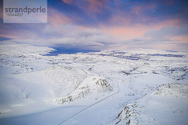Rosa Himmel bei Sonnenaufgang über Tanafjordveien Straße über die schneebedeckten Berge  Tana  Troms og Finnmark  Arktis  Nord-Norwegen  Skandinavien  Europa