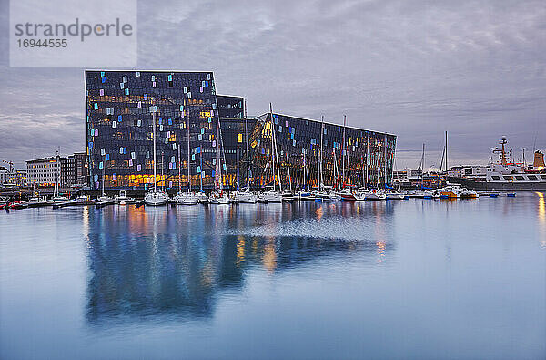 Ein abendlicher Blick auf die moderne Harpa-Konzerthalle  neben dem alten Hafen in Reykjavik  Südwestisland  Polarregionen