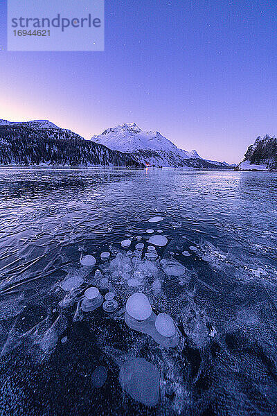 Eisblasen gefangen im Silser See mit Piz Da La Margna im Hintergrund in der Morgendämmerung  Engadin  Kanton Graubünden  Schweiz  Europa