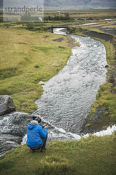 Tourist fotografiert den Gluggafoss (Fensterfall  auch Merkjarfoss genannt)  einen Wasserfall am Fluss Merkja  Südisland (Sudurland)