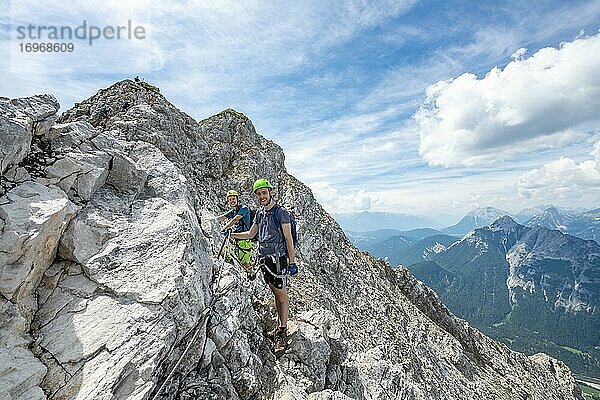 Bergsteiger klettern an einem gesicherten Klettersteig  Mittenwalder Höhenweg  Karwendelgebirge  Mittenwald  Bayern  Deutschland  Europa