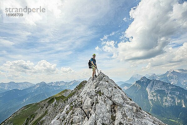Bergsteiger auf einem Grat an einem gesicherten Klettersteig  Mittenwalder Höhenweg  Ausblick auf Bergpanorama  Karwendelgebirge  Mittenwald  Bayern  Deutschland  Europa