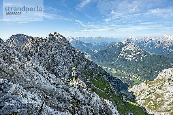 Bergsteiger klettert an einem gesicherten Klettersteig  Mittenwalder Höhenweg  Ausblick ins Isartal bei Mittenwald  Karwendelgebirge  Mittenwald  Bayern  Deutschland  Europa