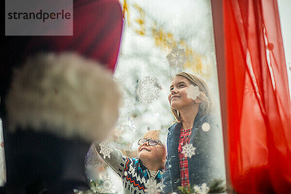 Kinder verbinden sich mit dem Weihnachtsmann durch das Fenster