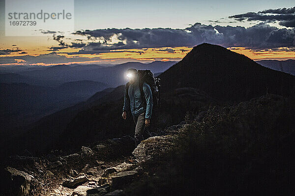 Wanderer auf einem Berggipfel in der Dämmerung mit Stirnlampe  Bigelow  Maine