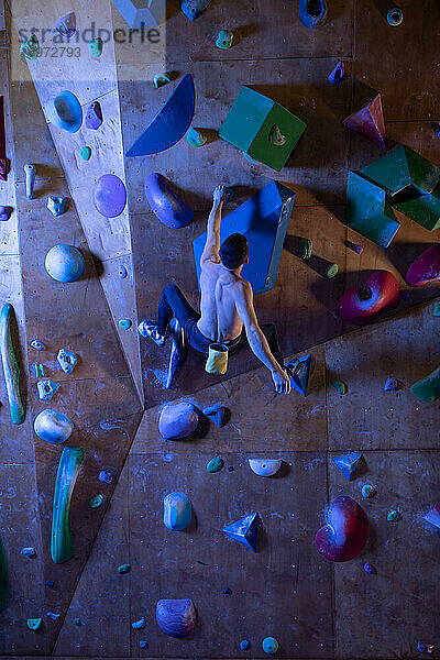 Anonymer Boulderer  der an einem Wandvorsprung hängt