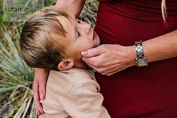 Kleiner Junge wird von seiner Mutter draußen getröstet