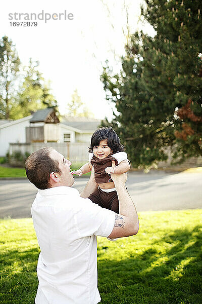 Vater hält seine Tochter im Park in die Luft