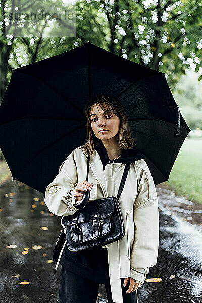 Frau mit Regenschirm an einem regnerischen Tag