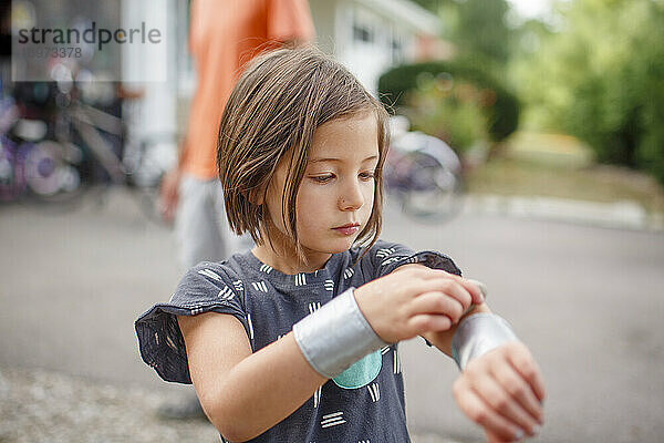 ein süßes Mädchen mit Krümeln auf den Lippen befestigt Armbänder