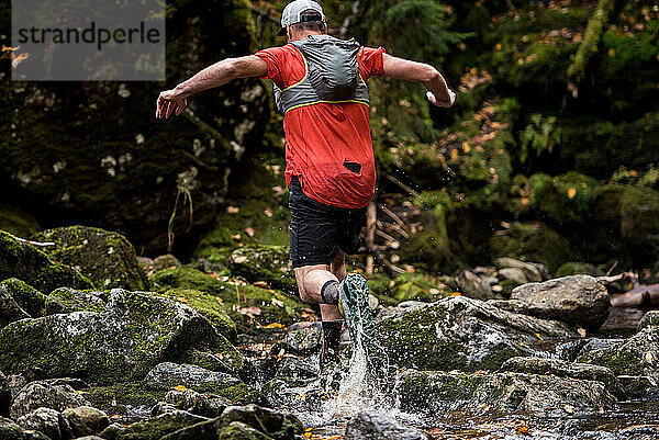 Mann  der durch das Wasser läuft und spritzt