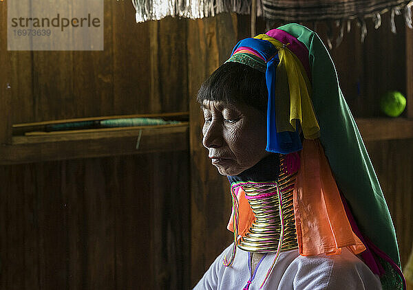 Ältere birmanische Frau vom Stamm der Kayan arbeitet in einer Textilwerkstatt