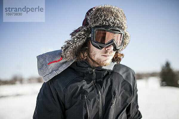 Porträt eines Mannes beim Snowboarden an einem kalten Wintertag