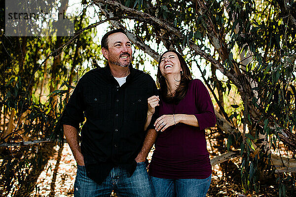 Ehemann und Frau lachen unter einem Baum in Chula Vista