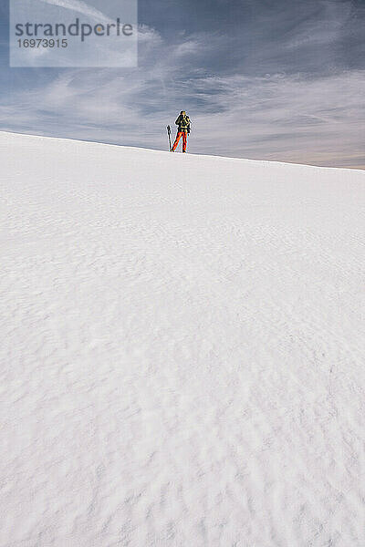 Junger Mann  der ein Foto auf einem Eisschnee gegen bewölkten Himmel macht  Gredos