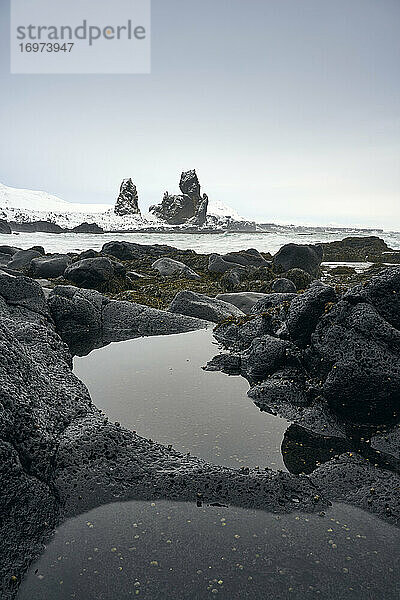 Verschneite Bucht mit ruhigem Wasser