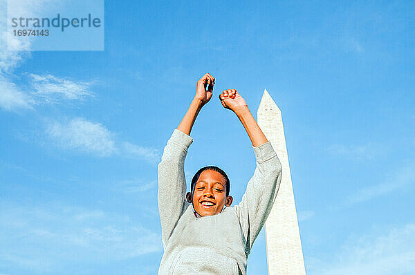 Junger afroamerikanischer Mann springt vor dem Washington Monument