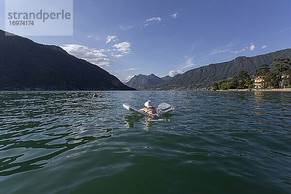 Eine Frau beim Sonnenbaden auf einem Floß auf einem See in Italien
