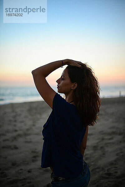 Junge Frau am Strand bei Sonnenuntergang