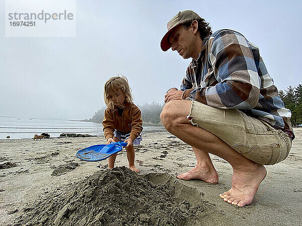 Ein Vater und seine Tochter spielen im Sand an der Küste von OR.