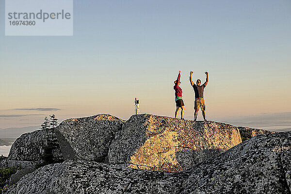 Mann und Frau feiern das Erreichen eines Berggipfels beim Wandern  Maine