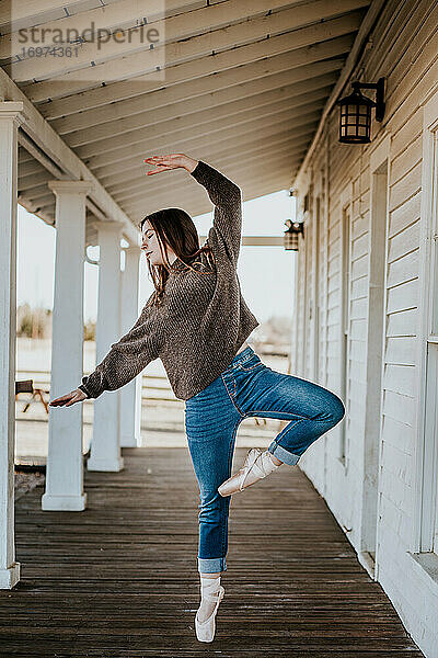 Teenager-Ballerina tanzt draußen auf der Terrasse an einem sonnigen Tag