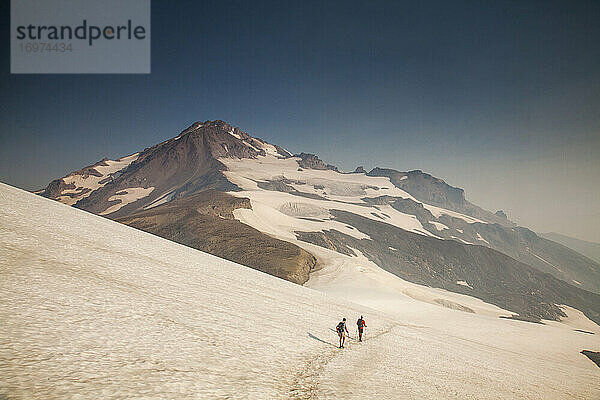 Zwei Wanderer klettern auf den Gipfel des Glacier Peak in Washington.