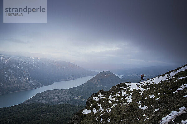 Ein junger Mann klettert auf dem Dog Mountain mit Blick auf die Columbia-Schlucht.