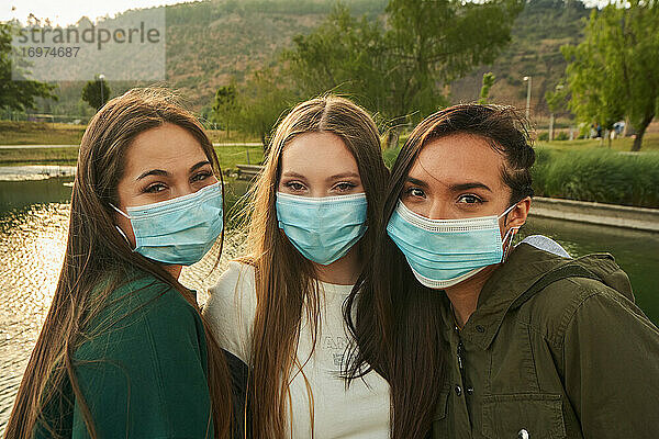 Eine Gruppe schöner junger Freundinnen  die mit Gesichtsmasken in einer