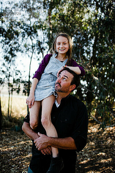 Tochter posiert auf Papas Schulter im Park in Chula Vista