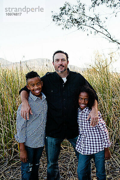 Vater posiert mit Söhnen im Park in Chula Vista