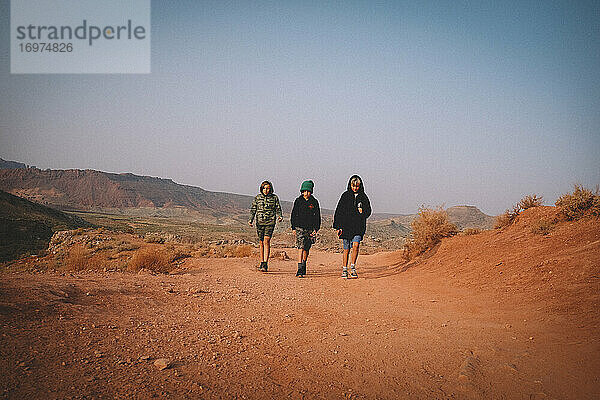 Drei Jungs zwischen zwei Jahren auf einer Wanderung in der Wüste.