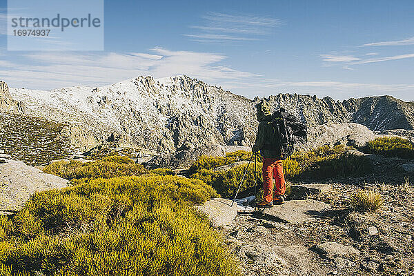 Junger Mann  der während einer Wanderpause seinen Zielgipfel betrachtet  Gredos  Avila  Spanien