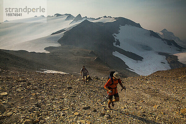 Zwei Wanderer klettern in der Morgendämmerung auf den Gipfel des Glacier Peak.