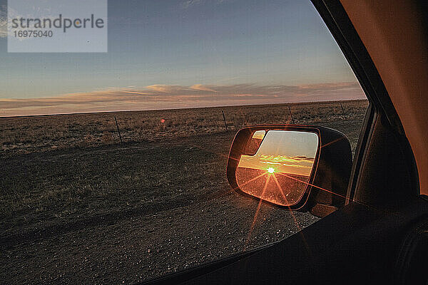 Sonnenaufgang im Rückspiegel eines Autos im mittleren Westen der USA reflektiert