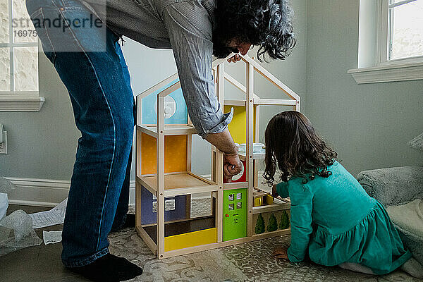 Vater und Tochter bauen ein Puppenhaus