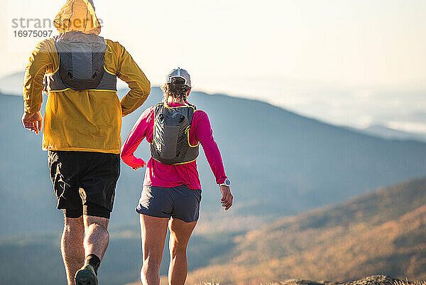 Mann und Frau beim morgendlichen Trailrunning in den Bergen