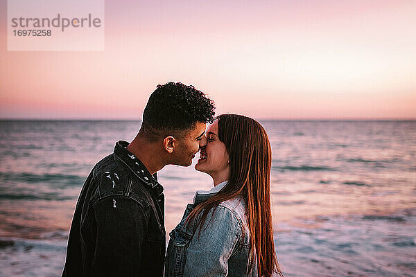 Junges verliebtes Paar küsst sich vor dem Meer