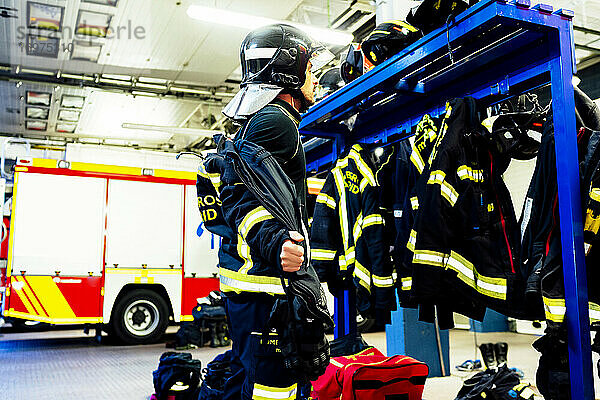 Feuerwehrmann  der sich für einen Notfall umzieht