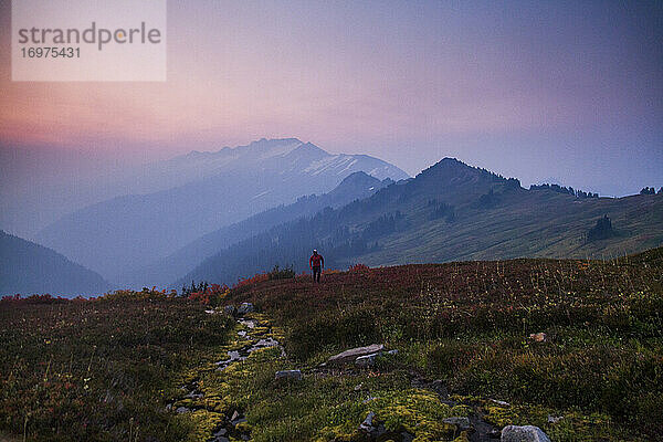 Ein Wanderer besteigt den Glacier Peak im frühen Morgenlicht in Washington.
