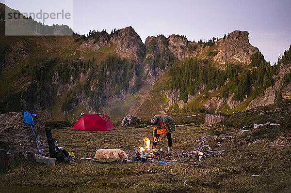 Camping im alpinen Hinterland mit Lagerfeuerzelt und Hund