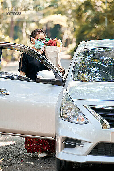 Frau hält eine Papiertüte nach einem Einkauf während der COVID-19-Pandemie